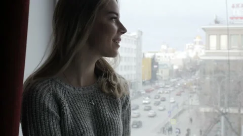 Girl is smiling looking out the window Video stock 85969433