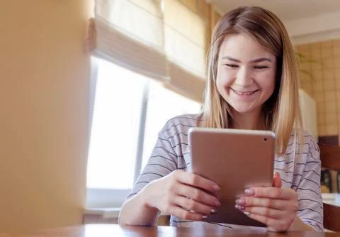 Girl smiling while looking at tablet screen Stock Photos
