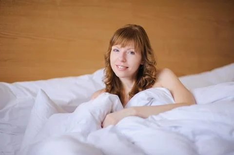 Girl smiling while lying in bed Stock Photos