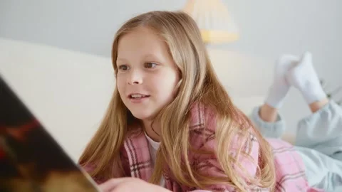 Girl smiling while reading on bed Stock Footage 311919148