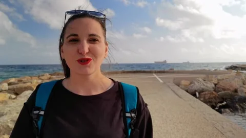 A girl smiling while singing and dancing on the sea pier in Civitavecchia Stock Footage 251764095