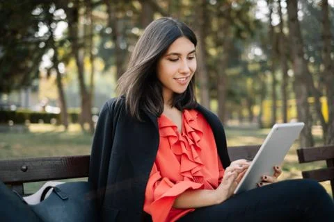 Girl smiling while using tablet in the park Stock Photos