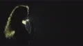 The girl smoke electronic cigarette on the dark background. Slow motion capture 4k or 4k+ Resolution