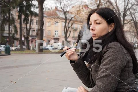Girl smoking electronic cigarette, Iqos system Stock Photos