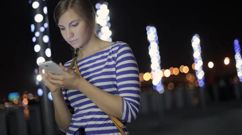 Girl sms texting using app on smart phone at night Stock Footage 54004089