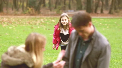 Girl sneaking up to her parents and surprising them Stock Footage 59554572