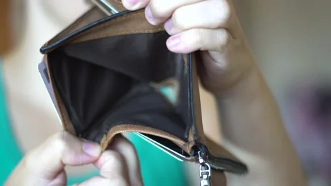 Girl sniffs empty wallet with a hole Stock Footage 138866679