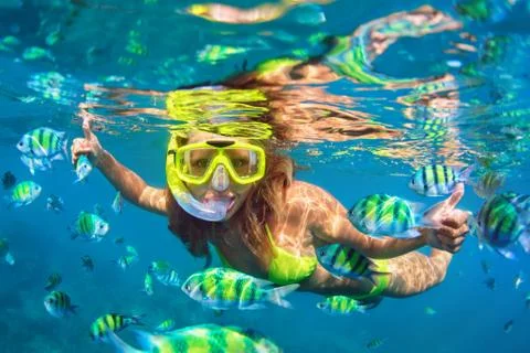 Girl in snorkeling mask dive underwater with coral reef fishes Stock Photos