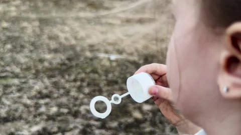 Girl with soft braids playing with bubbles, peaceful mood in the countryside Stock Footage 315532785