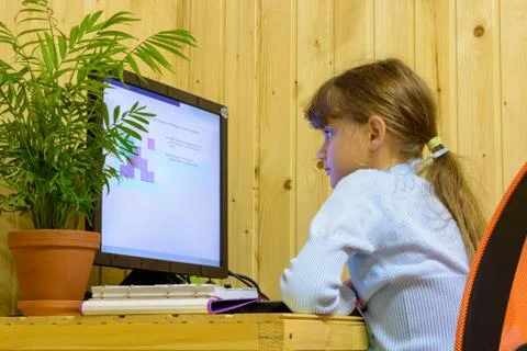 A girl solves a problem on a computer during distance learning Stockfoto's