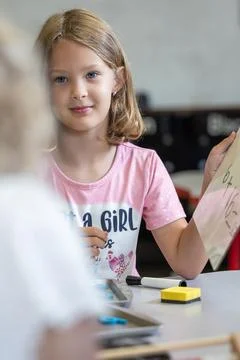 A girl is solving a math problem on a white board. Stock Photos