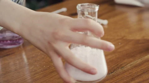 Girl spilling powder on table while experiment Stock Footage 63861575