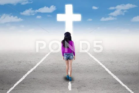 Girl in a spiritual journey with a cross Stock Photos