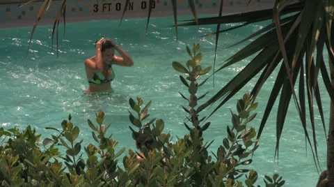 Girl Splashes Into Pool from Waterslide Stock Footage 25879591