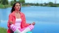 Girl in sportswear sits near the lake and meditates HD Footage