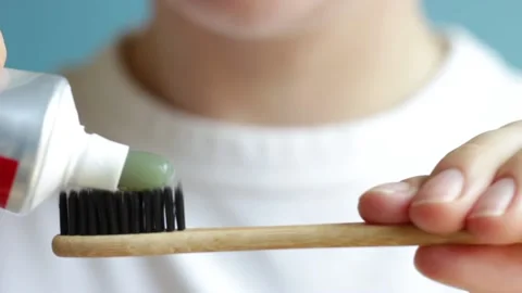 Girl squeezes toothpaste on a toothbrush close-up, front view. Stock Footage 154202841
