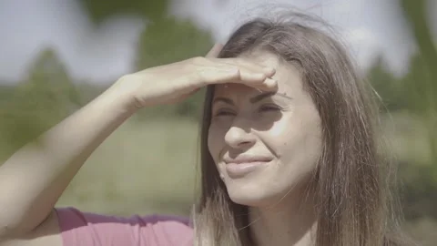 The girl squints at the sun and puts on sunglasses. Stock Footage 243685996