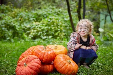 A girl with a stack of pumpkins. Stock Photos