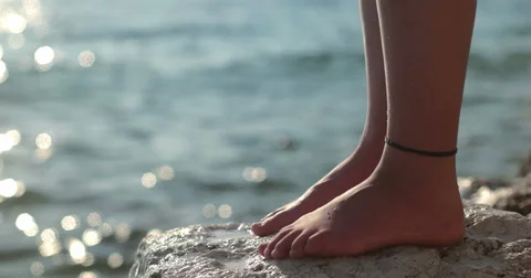 Girl standing on the cliff and splashed with water, only foot visible Stock-Footage 52597770