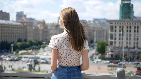 The girl is standing with her back to the camera. She has long hair flapping in Video stock 99409387