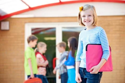 Girl Standing Outside School With Book Bag Stock Photos