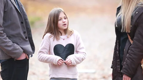 Girl standing in park and talking with parents Stock Footage 59554258