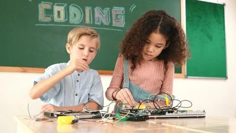 Girl standing while fixing electronic board by using screwdriver. Pedagogy. Stock-Fotos