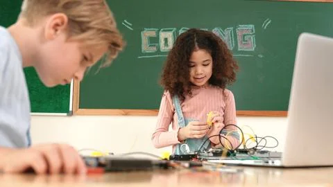 Girl standing while fixing electronic board by using screwdriver. Pedagogy. Stock Photos