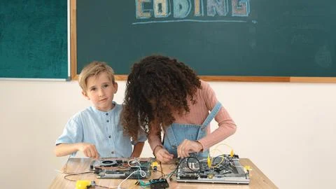 Girl standing while fixing electronic board by using screwdriver. Pedagogy. Stock Photos