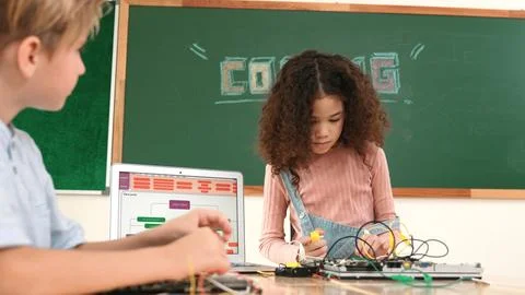 Girl standing while fixing electronic board by using screwdriver. Pedagogy. Stock Photos