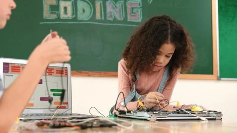 Girl standing while fixing electronic board by using screwdriver. Pedagogy. Stock Photos