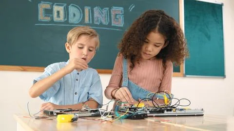 Girl standing while fixing electronic board by using screwdriver. Pedagogy. Stock-Fotos