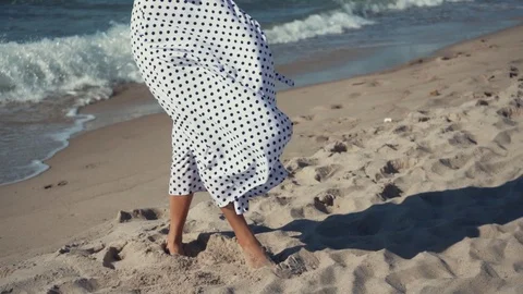 Girl stands on the beach in white dress Stock Footage