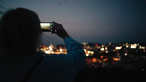 A girl stands in front of the lights of a large night city Stock Footage 286351334