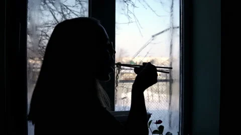 The girl stands at the window and eats top ramen. Eating instant noodles Stock Footage 149225069