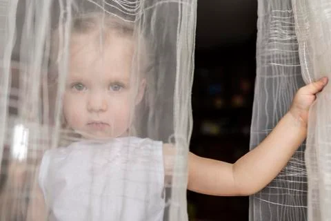 Girl staring behind translucent curtains Stock Photos