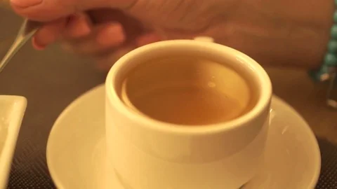 Girl stir the sugar in a mug of tea Stock Footage