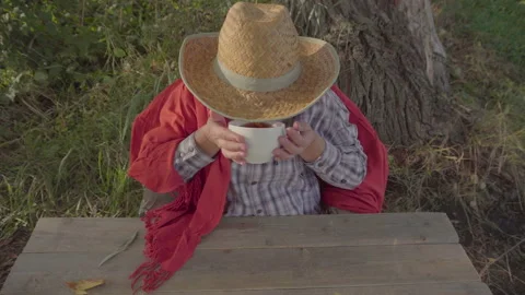 Girl in straw hat drinking tea top view 4K Stock Footage 95765746