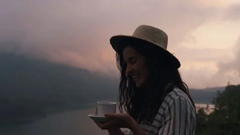 Girl in a straw hat drinks coffee Stock Footage 129056381