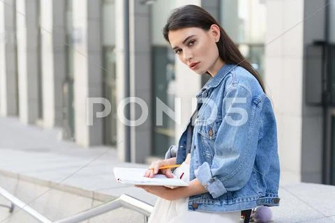 Girl on the street drawing and looking in a camera Stock Photos