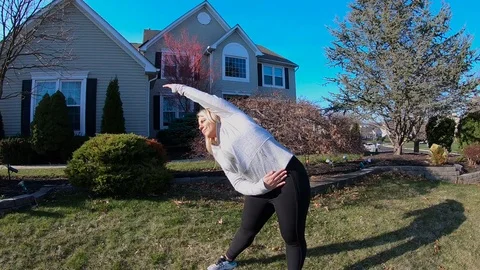 Girl Stretching from side to side outside in slow motion Stock Footage 127140129