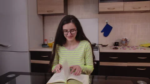 Girl student at home preparing for study, reading a textbook Stock Footage 130194509