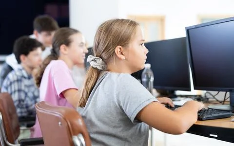Girl student learning to work on computer in classroom Foto stock