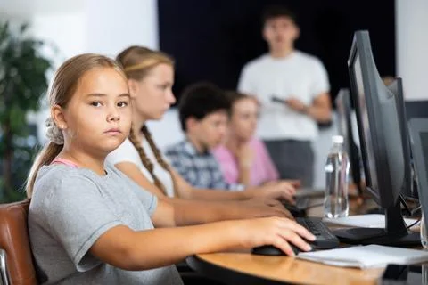 Girl student learning to work on computer in classroom Foto stock
