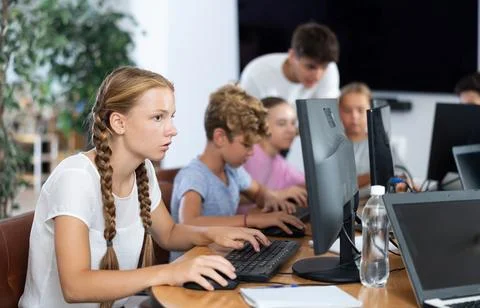 Girl student learning to work on computer in classroom Foto stock