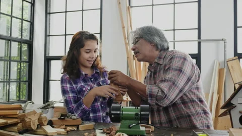 Girl student practicing woodworking from elderly carpenter build objects Stock Footage 159665086