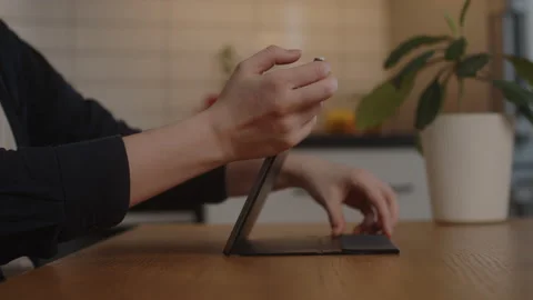 Girl student sits down at the table to do the work or do the task on the tablet Stock Footage 171463003