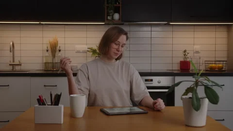 Girl student sits down at the table to do the work or do the task on the tablet Stock Footage 171463301