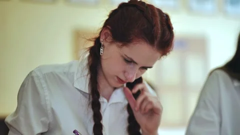 A girl student writes math formulas in a notebook. Stock Footage 258797696