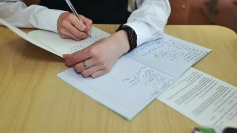 A girl student writes math formulas in a notebook. Notebook close-up. Stock Footage 258797738